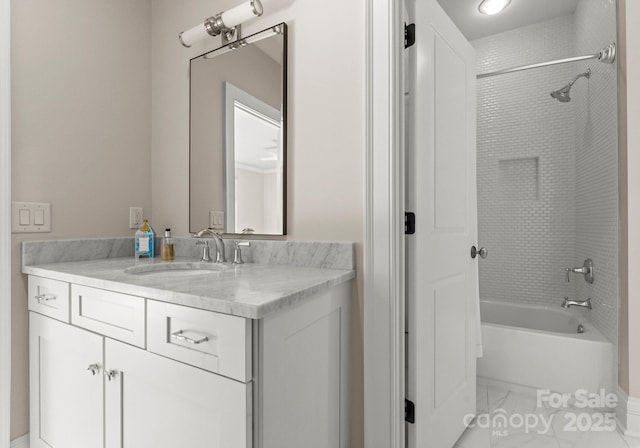 bathroom featuring tiled shower / bath and vanity