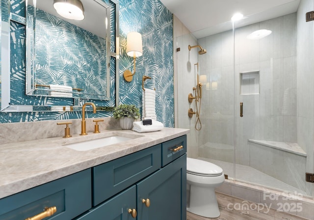 bathroom featuring vanity, hardwood / wood-style floors, a shower with door, and toilet