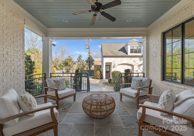 view of patio / terrace with ceiling fan and an outdoor living space with a fireplace