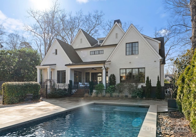 back of house featuring a fenced in pool, a patio, and ceiling fan