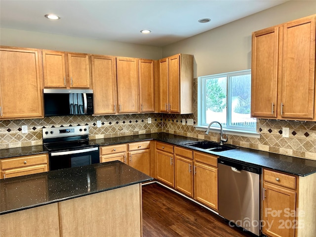 kitchen featuring tasteful backsplash, dark wood-style flooring, stainless steel appliances, a sink, and recessed lighting