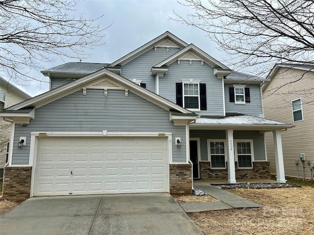 view of front of home with a porch, concrete driveway, and brick siding