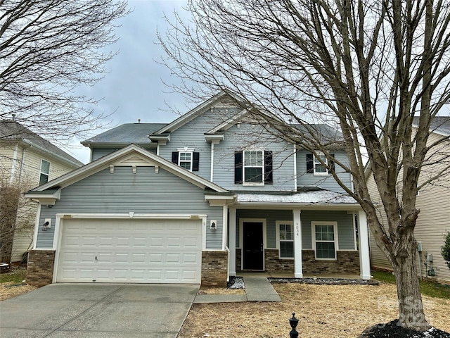 craftsman house featuring a porch, concrete driveway, brick siding, and a garage