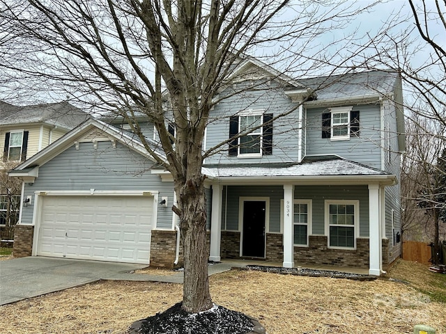 view of front of property featuring an attached garage, covered porch, driveway, and brick siding