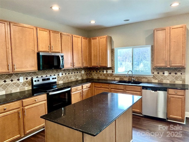 kitchen with appliances with stainless steel finishes, a center island, a sink, and tasteful backsplash