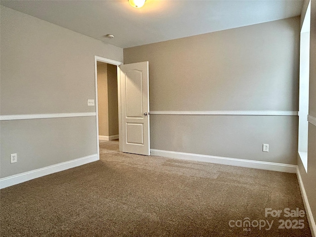 carpeted spare room with baseboards