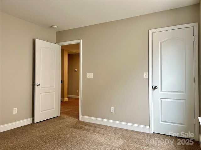 unfurnished bedroom with carpet floors and baseboards