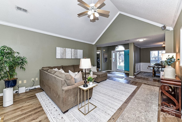 living room featuring vaulted ceiling, ornamental molding, and hardwood / wood-style flooring