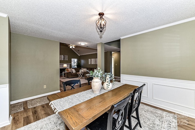 dining space featuring crown molding, a textured ceiling, and lofted ceiling