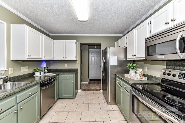 kitchen with light tile patterned floors, a textured ceiling, white cabinets, and stainless steel appliances