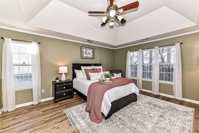 bedroom featuring ceiling fan, a raised ceiling, and hardwood / wood-style floors