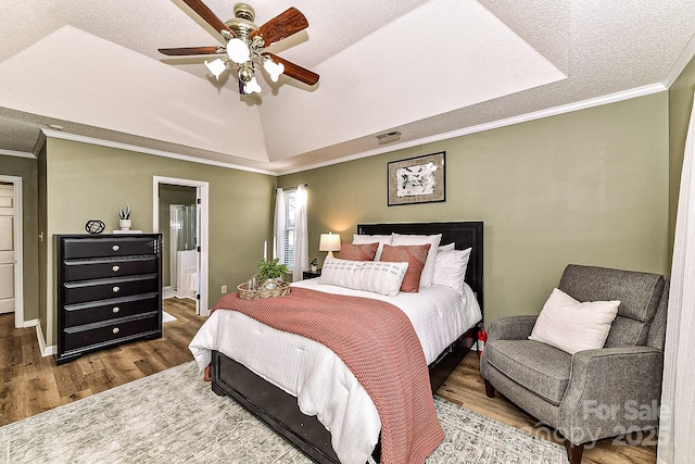 bedroom featuring ceiling fan, a raised ceiling, a textured ceiling, and wood-type flooring