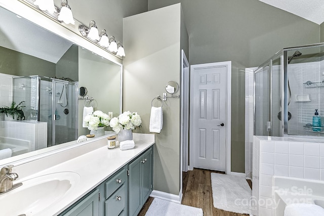 bathroom with hardwood / wood-style floors, plus walk in shower, and vanity