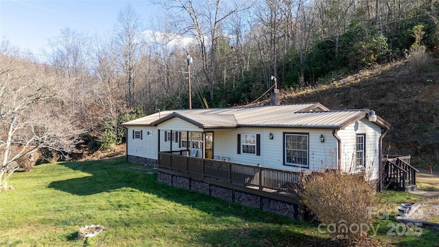 rear view of house featuring a wooden deck and a yard