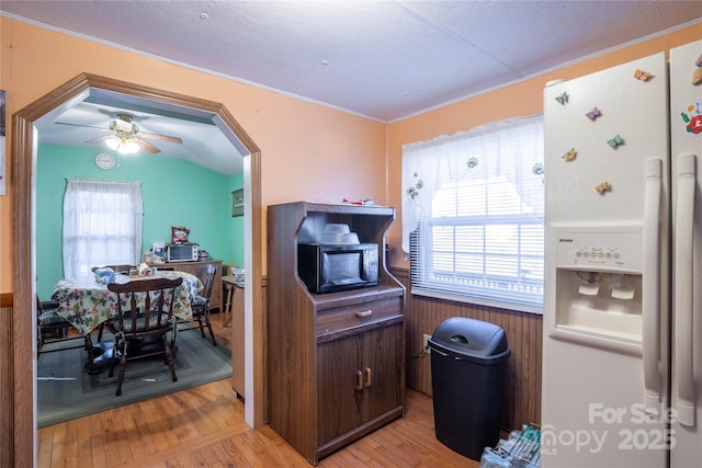 kitchen with light wood-type flooring, ceiling fan, white fridge with ice dispenser, and dark brown cabinetry