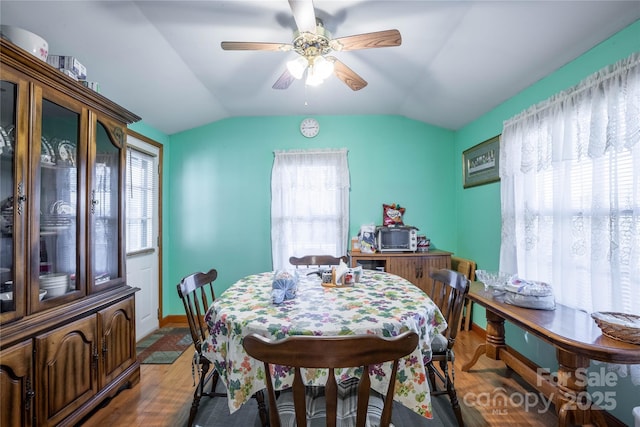 dining area featuring ceiling fan, hardwood / wood-style floors, and lofted ceiling