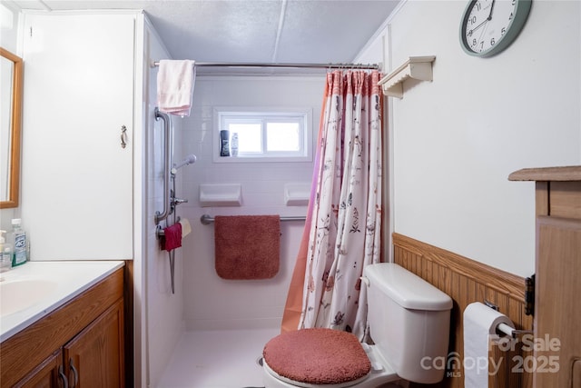 bathroom featuring toilet, walk in shower, and vanity