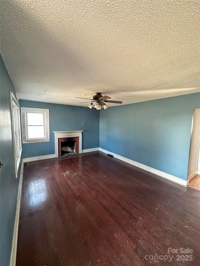 unfurnished living room with wood-type flooring, a textured ceiling, ceiling fan, and a fireplace