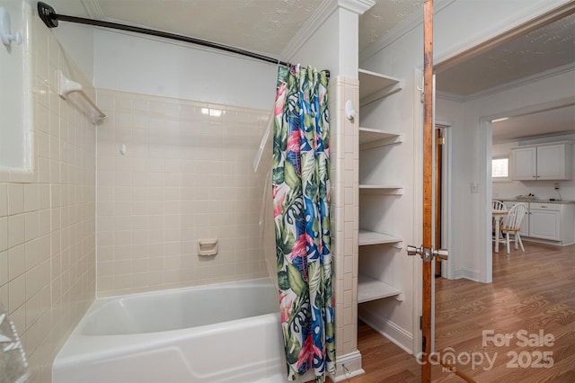 bathroom featuring wood-type flooring, ornamental molding, and shower / tub combo