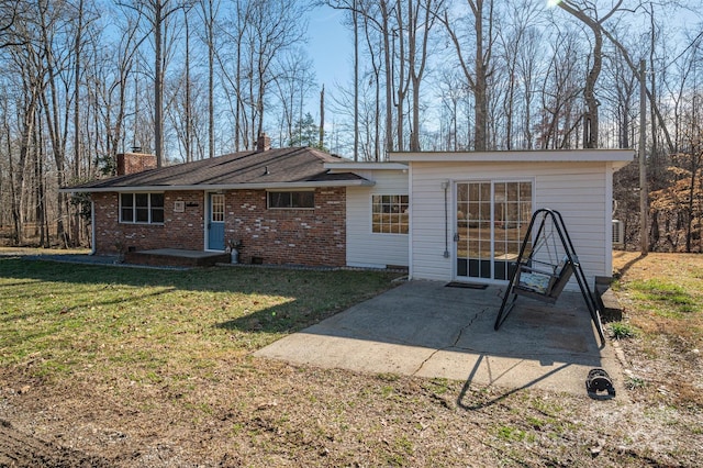 rear view of property featuring a patio and a lawn