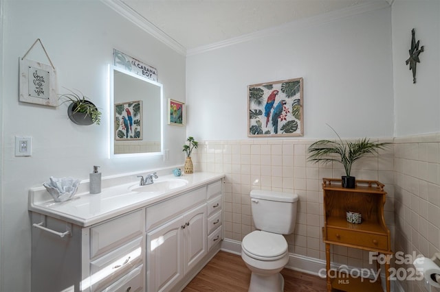 bathroom with hardwood / wood-style flooring, ornamental molding, tile walls, toilet, and vanity