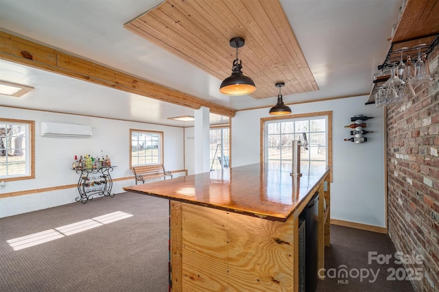 kitchen with a wall mounted air conditioner, brick wall, dark carpet, beamed ceiling, and pendant lighting