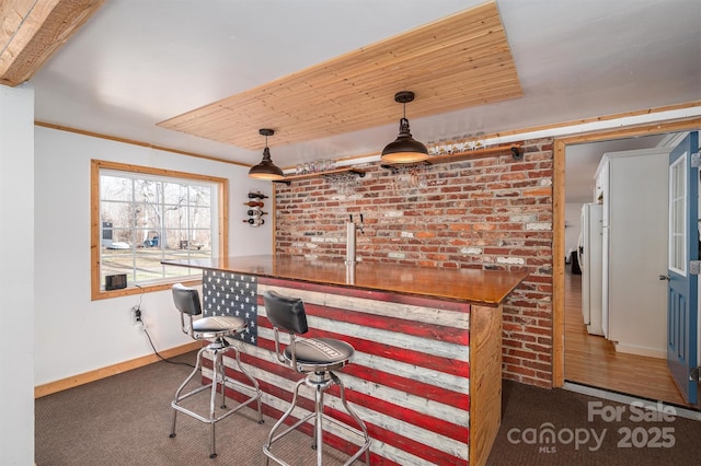 bar with wooden ceiling, brick wall, and pendant lighting