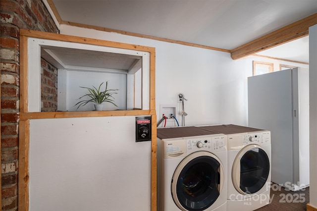 laundry area featuring washing machine and dryer and brick wall