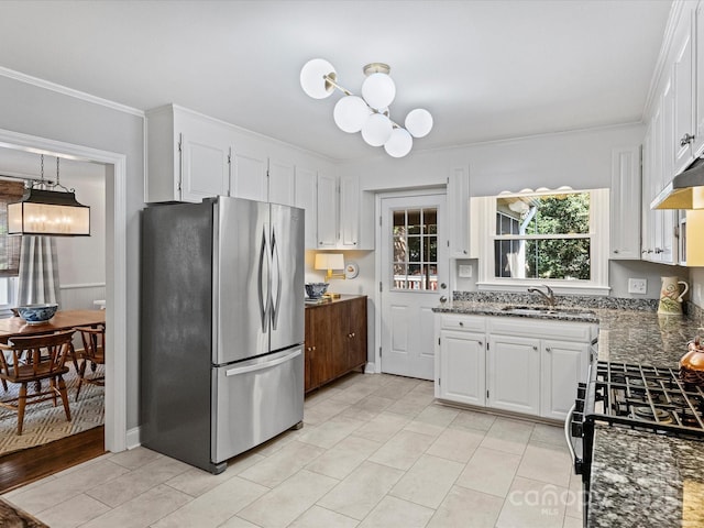 kitchen with sink, white cabinetry, a notable chandelier, and stainless steel refrigerator