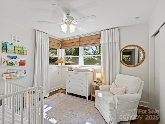 bedroom featuring ceiling fan, a nursery area, a closet, and crown molding