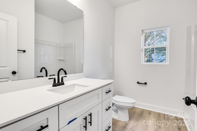 bathroom featuring hardwood / wood-style flooring, toilet, and vanity