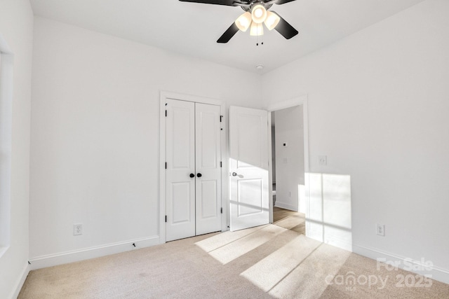 unfurnished bedroom with ceiling fan, light colored carpet, and a closet