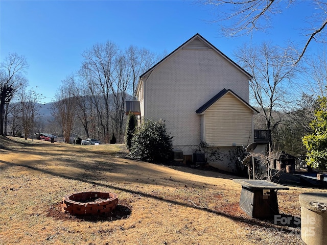 view of property exterior with a mountain view and a fire pit