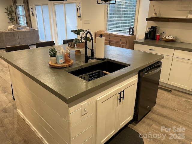 kitchen featuring white cabinetry, sink, dishwasher, and light wood-type flooring