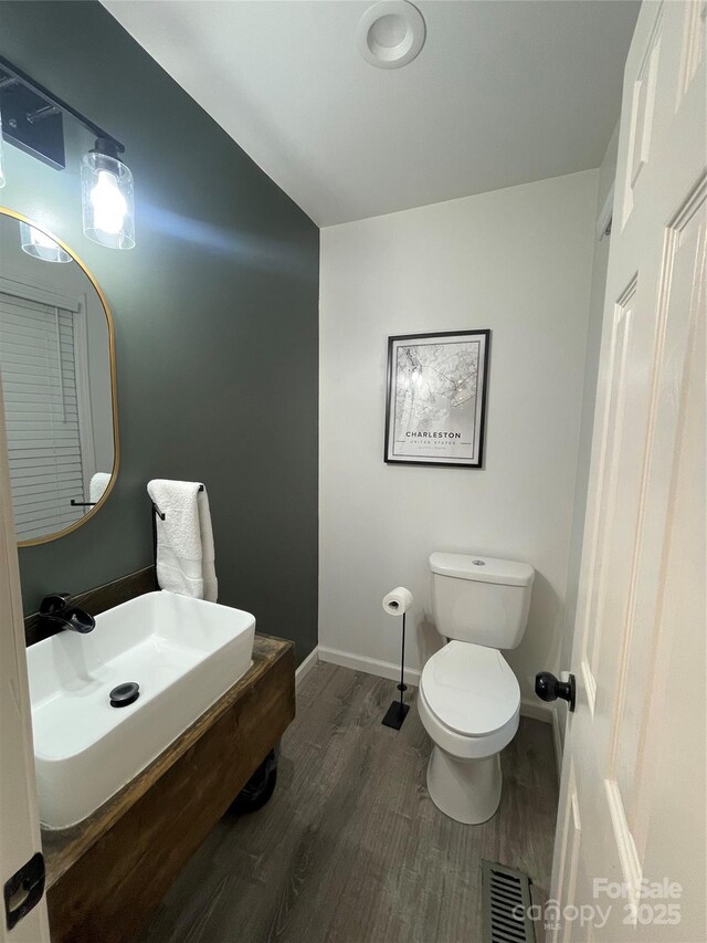 bathroom featuring hardwood / wood-style floors and toilet