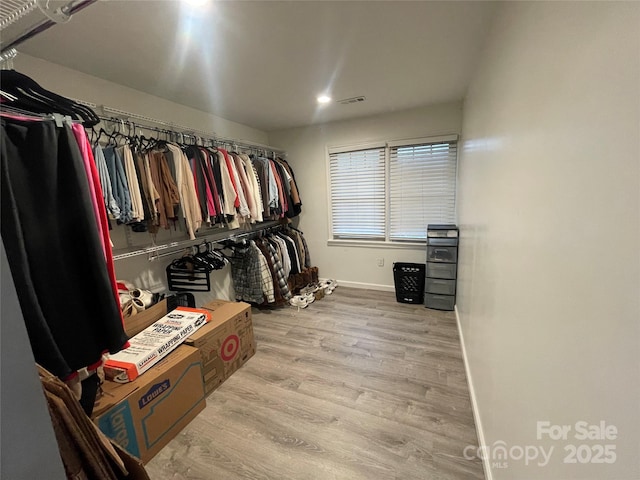 walk in closet with light wood-type flooring