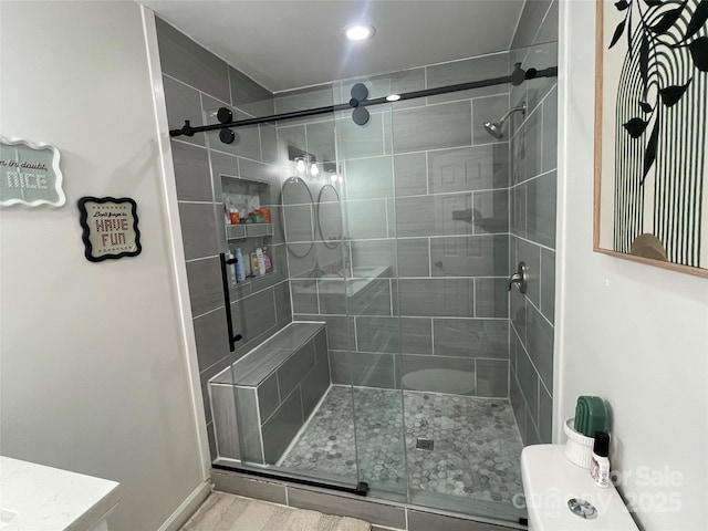 bathroom featuring toilet and a shower with door