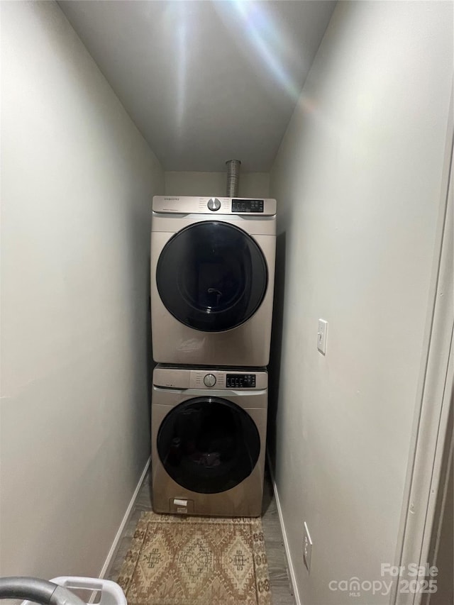 clothes washing area featuring stacked washer and clothes dryer and wood-type flooring