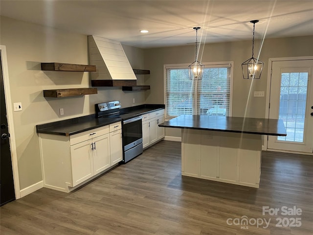 kitchen with a center island, dark hardwood / wood-style floors, pendant lighting, stainless steel electric stove, and white cabinets