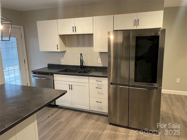 kitchen featuring sink, light hardwood / wood-style floors, white cabinets, and appliances with stainless steel finishes