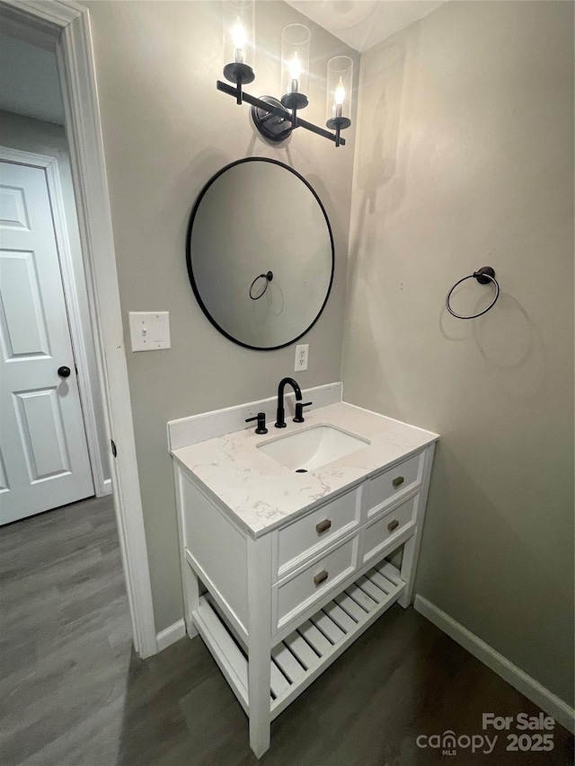 bathroom featuring hardwood / wood-style flooring, vanity, and a notable chandelier