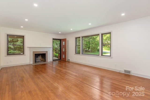 unfurnished living room with a fireplace and light hardwood / wood-style floors