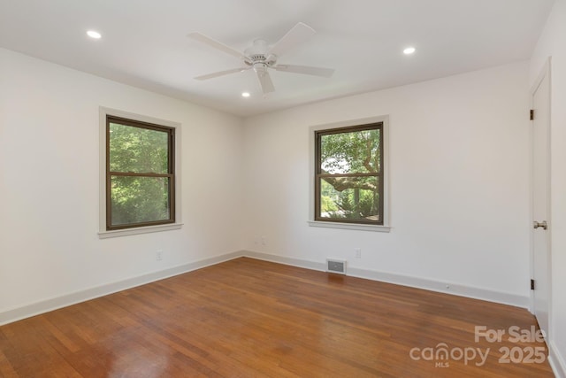 spare room with hardwood / wood-style floors and ceiling fan