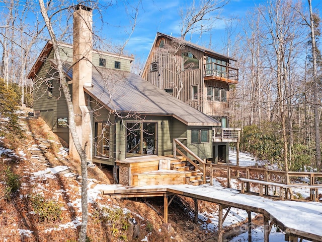 snow covered property with a deck and a balcony