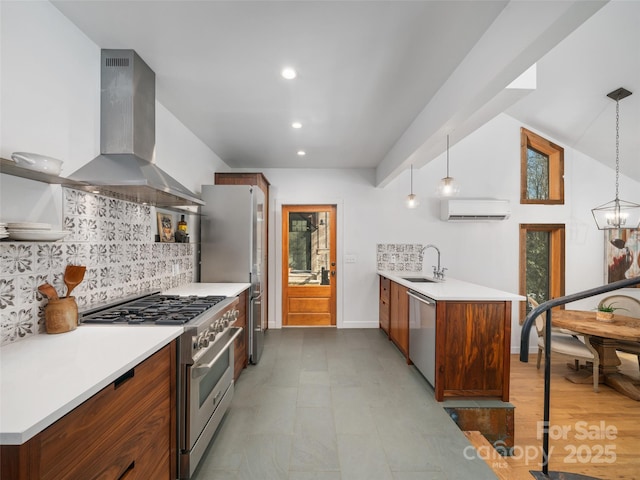 kitchen featuring extractor fan, appliances with stainless steel finishes, pendant lighting, an AC wall unit, and sink