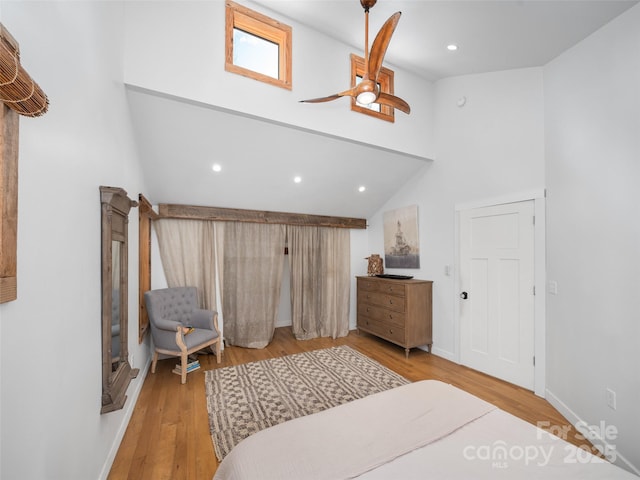 bedroom with ceiling fan, high vaulted ceiling, and light hardwood / wood-style flooring