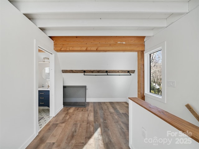 walk in closet featuring beamed ceiling, hardwood / wood-style floors, and sink