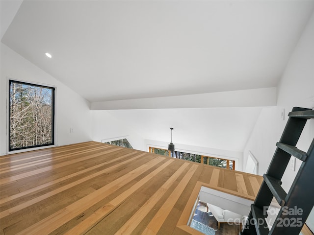 staircase featuring wood-type flooring and lofted ceiling