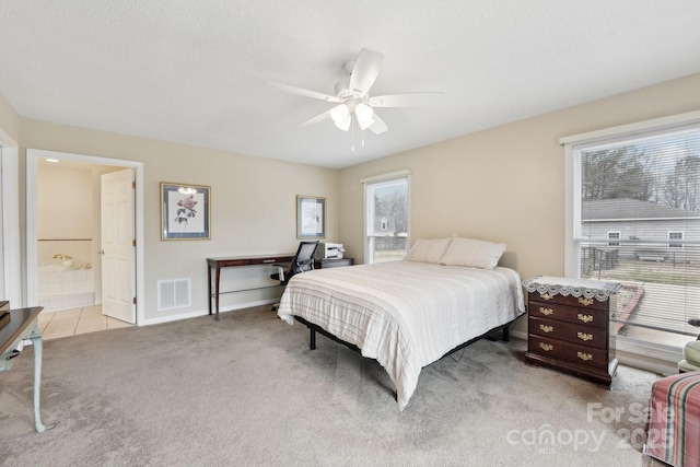 carpeted bedroom featuring ensuite bathroom, a textured ceiling, and ceiling fan