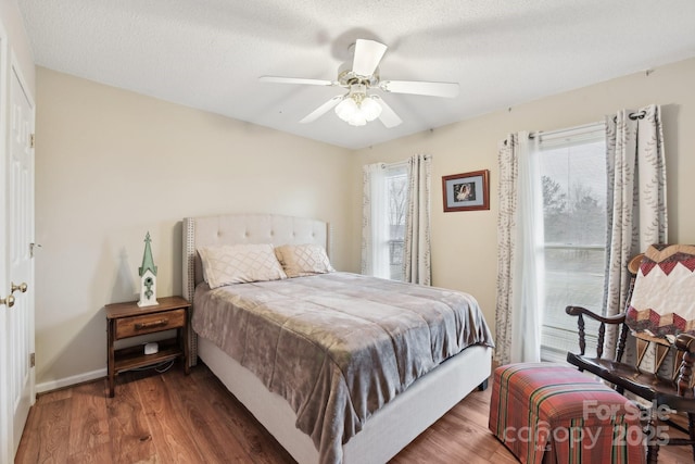 bedroom featuring dark hardwood / wood-style floors, a textured ceiling, and ceiling fan